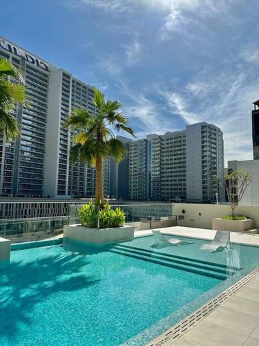 een zwembad op de top van een gebouw met palmbomen bij Stunning Studio in Business Bay in Dubai