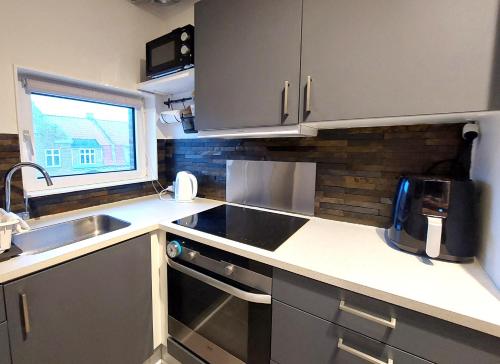 a small kitchen with a sink and a stove at Nordic style apartment in central Aalborg with a beautiful city view in Aalborg