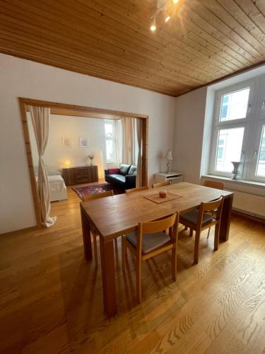 uma sala de estar com uma mesa de madeira e cadeiras em Altbauwohnung mit 2 Balkonen em Wuppertal