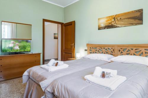- une chambre avec un grand lit et des serviettes dans l'établissement Sailing Ships Cozy flat x5 with balcony, à La Spezia