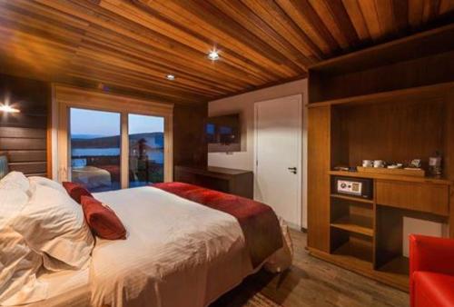 a bedroom with a bed and a large window at Bourbon Serra Gaúcha Divisa Resort in São Francisco de Paula