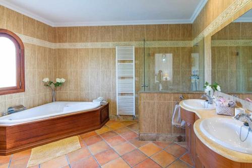a large bathroom with a tub and two sinks at Villa Sanchez in Campos