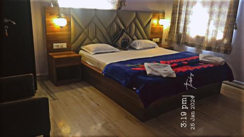 a bedroom with a bed with a blue comforter at Quinte Hills Residency in Panchgani
