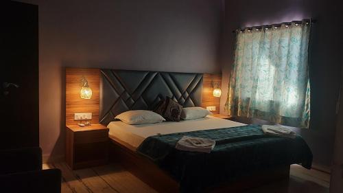 a bedroom with a bed with a blue curtain at Quinte Hills Residency in Panchgani