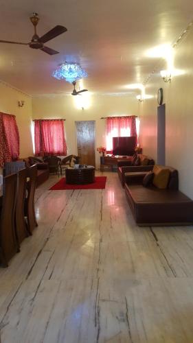 a living room with couches and a ceiling fan at Quinte Hills Residency in Panchgani