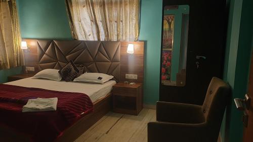 a small bedroom with a bed and a chair at Quinte Hills Residency in Panchgani
