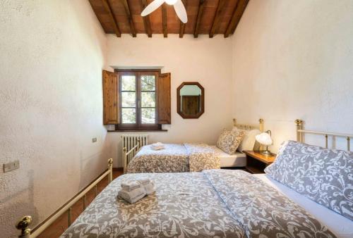 1 dormitorio con 2 camas y espejo en Podere Boscone, en Gambassi Terme