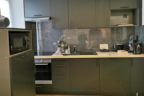 a kitchen with a sink and a microwave at Appart Hotel Spa Perpignan in Perpignan
