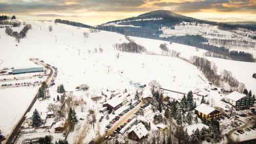 a snow covered ski slope with a ski lodge at Pension Imlauf in Vrchlabí