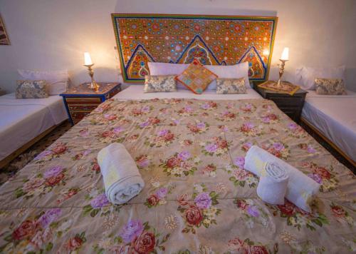 a bedroom with a large bed with towels on it at Riad Fes Hayat - Confort Stay in Fès