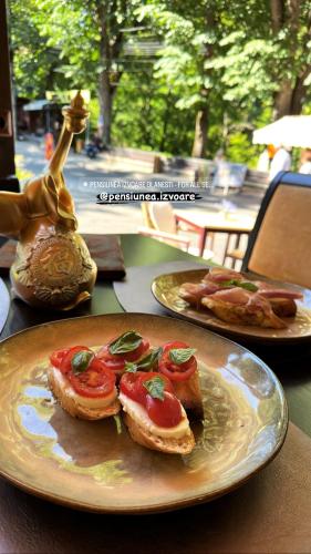 een bord eten met broodjes op tafel bij Pensiunea Izvoare Olanesti 3*** in Băile Olăneşti