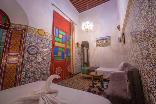 a room with two beds and a colorful door at Riad Fes Hayat - Confort Stay in Fès