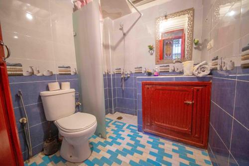 a bathroom with a toilet and a red cabinet at Riad Fes Hayat - Confort Stay in Fès