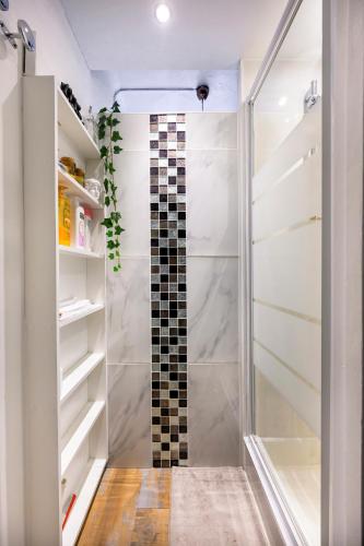 - un dressing avec une douche en verre dans l'établissement Studio calme proche Tour Eiffel, à Paris