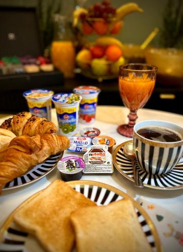 a table topped with plates of pastries and a cup of coffee at Triton Park Apartments in Warsaw