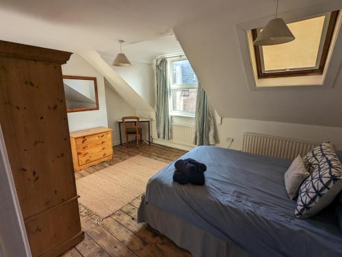 une chambre avec un lit, une commode et une fenêtre dans l'établissement Lavender House Weymouth, à Weymouth