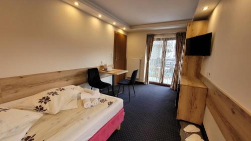 ウストロンにあるASENATA Ustroń Centrumのベッドとデスクが備わるホテルルームです。