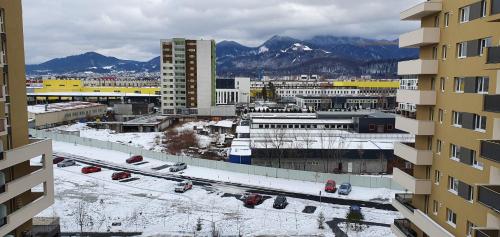 - une vue sur une ville avec des bâtiments enneigés et des montagnes dans l'établissement Urban Alexa Home, à Braşov