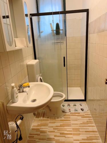 a bathroom with a toilet and a sink and a shower at 旅途之家 in Mestre