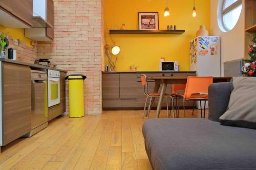 une cuisine avec des murs jaunes et une table avec des chaises dans l'établissement Grand appartement T2 au calme avec place de Parking privative, à Aix-en-Provence