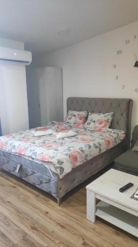 a bed sitting in a room with a table at Stan na dan Loznica in Loznica