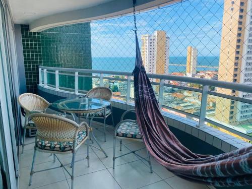 a hammock on a balcony with a table and chairs at Cantinho de Iracema in Fortaleza