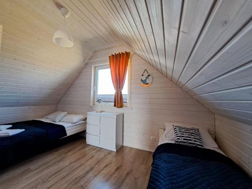 a bedroom with two beds and a window at Comfortable holiday homes for 7 people, Niechorze in Niechorze