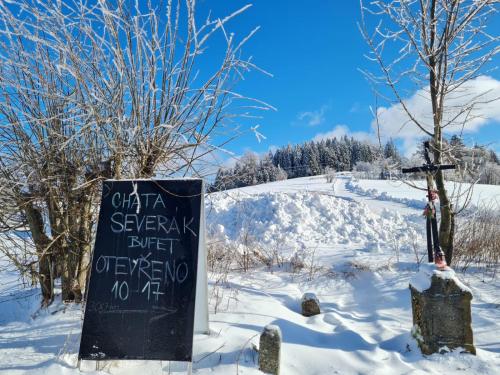 a sign in the snow next to a cemetery at Horský apartmán Stella in Janov nad Nisou