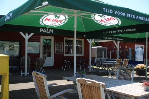a table with an umbrella in front of a restaurant at Camping de Kuilen in Someren