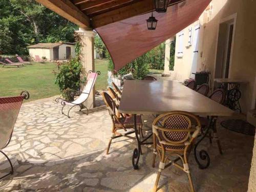 una mesa y sillas en un patio en Maison Blum, en Saint-Laurent-des-Arbres