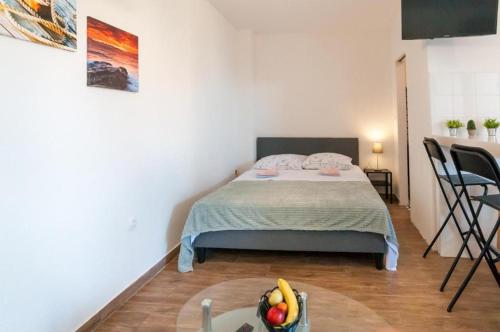 a bedroom with a bed and a table with a bowl of fruit at Ellena Sunshine in Opatija
