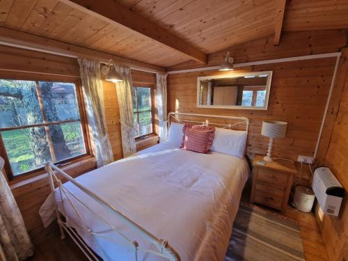 a bedroom with a bed in a log cabin at Cherry Orchard Retreat in Chideock