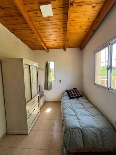 a bedroom with a bed and a wooden ceiling at Casa en Andino con pileta in Andino