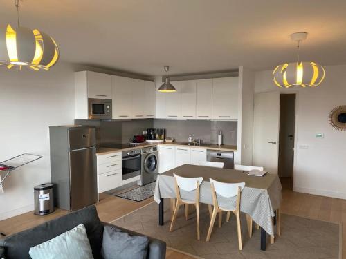 une cuisine et un salon avec une table et des chaises dans l'établissement Appartement à l'entrée d'Arcachon vue bassin, à La Teste-de-Buch