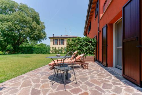 a patio with a table and bench and a house at B&B Hole6 in Castenaso