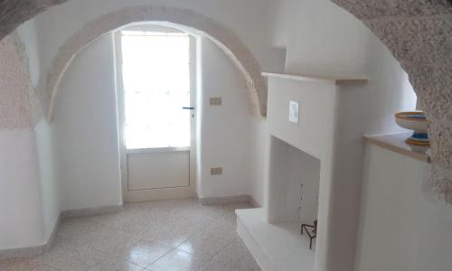 an arched hallway with a door and a window at Dimora Sumerano in Alberobello