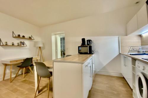 - une cuisine avec un comptoir, un four micro-ondes et une table dans l'établissement Le Jeu de Paume - T2 in the city center!, à Montpellier