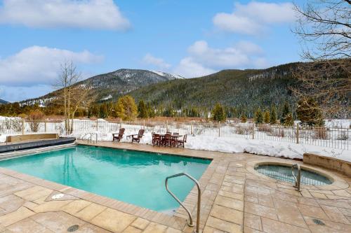 a swimming pool with snow covered mountains in the background at Red Hawk Lodge 2200 in Dillon