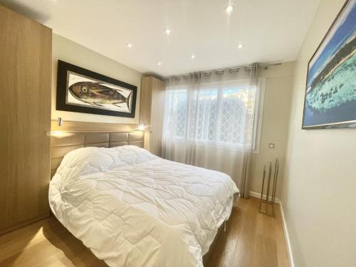 1 dormitorio con cama blanca y ventana en Rosalia Luxury 3 bedrooms near beaches by Welcome to Cannes, en Cannes