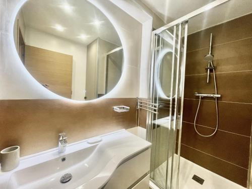 La salle de bains est pourvue d'un lavabo et d'une douche avec un miroir. dans l'établissement Rosalia Luxury 3 bedrooms near beaches by Welcome to Cannes, à Cannes