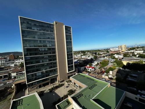 a tall building with a tennis court in front of a city at Departamento en centro de talca in Talca