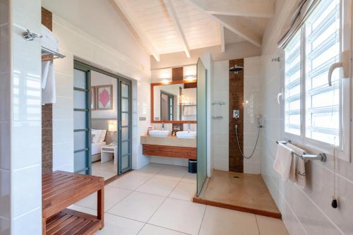 a bathroom with a tub and a sink and a toilet at Palm Beach Resort & Spa in Ambondrona