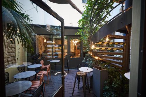 eine Terrasse mit Tischen, Stühlen und Pflanzen in der Unterkunft Madrigal in Paris