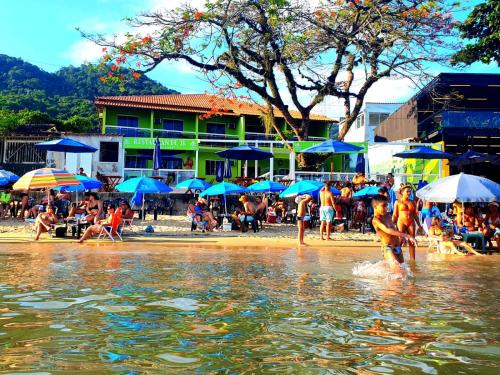 a group of people playing in the water on a beach at Pousada e Restaurante J L . in Mangaratiba