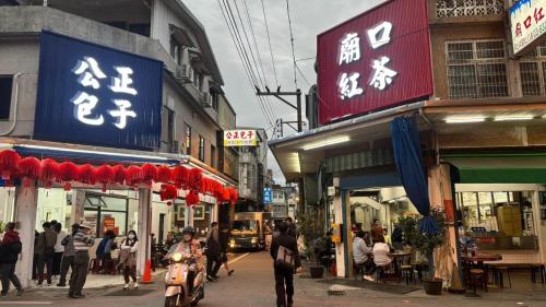 花蓮市的住宿－花蓮包棟-五指山民宿-近東大門夜市-有洗烘衣機-可停重機，一条繁忙的城市街道上的人和建筑物的标志