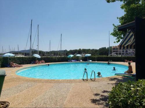 uma piscina com duas pessoas na água em MARCOGVER - Golfe de St-Tropez - Studio pour 2 personnes vue sur la marina em Cogolin