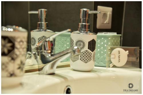 um lavatório de casa de banho com duas garrafas de sabão e um espelho em DEA DREAMS Amendola Fiera Apartment Free Wi-Fi em Milão