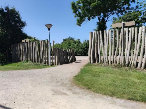 a wooden fence next to a dirt road at Modern 6P Tiny SolHouse 6 - Near Groningen in Kropswolde