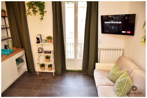 DEA DREAMS Amendola Fiera Apartment Free Wi-Fi في ميلانو: غرفة معيشة مع أريكة ونافذة