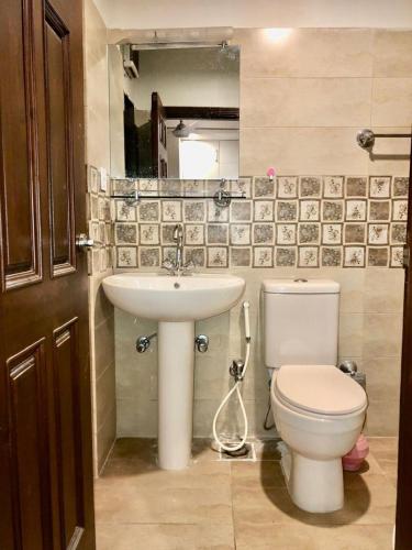 a bathroom with a toilet and a sink at Stylish & Serene 2BHK Apt in Islamabad